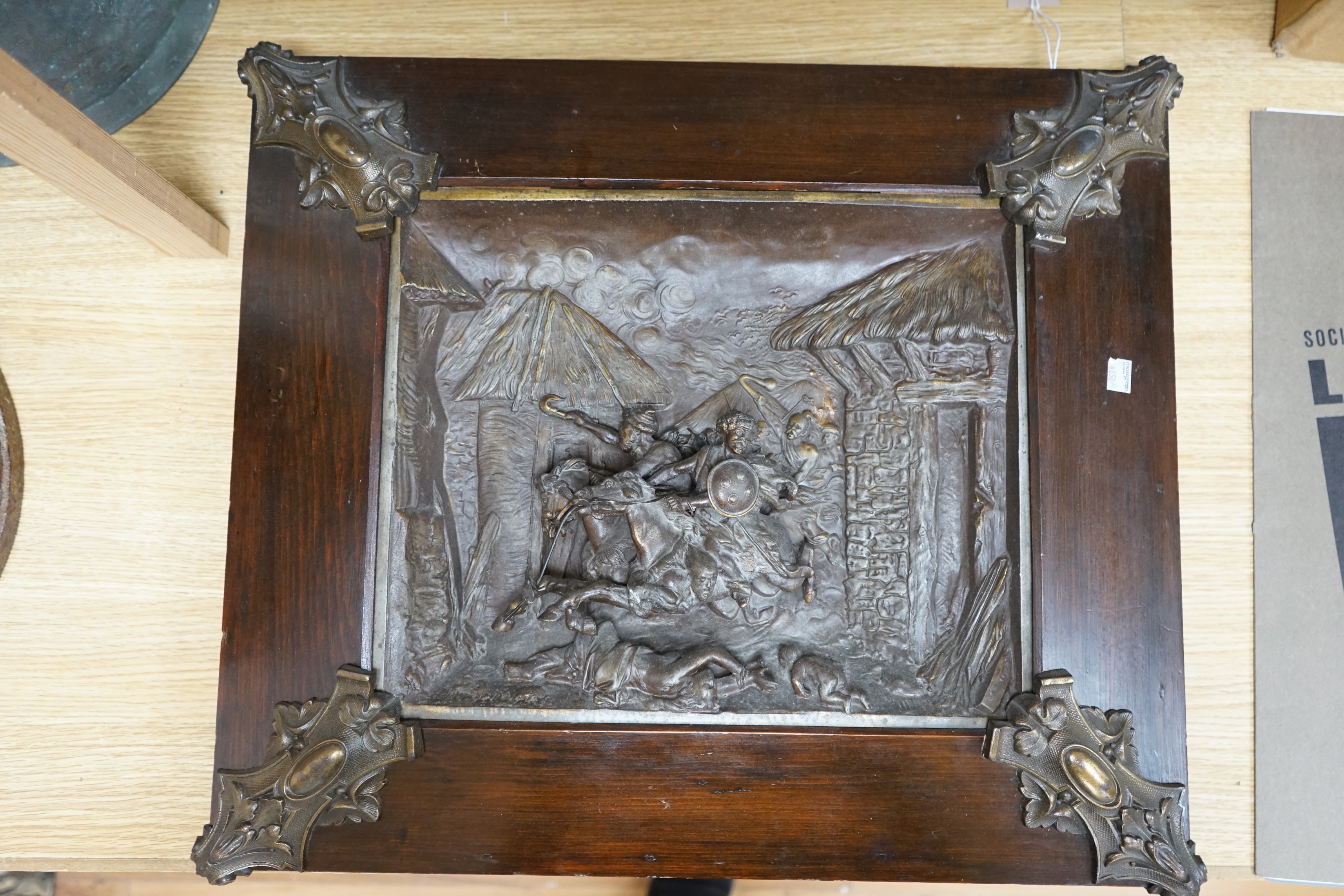 A framed spelter relief plaque, of the Mongols in battle, 59cm wide, 51 cm high, including frame